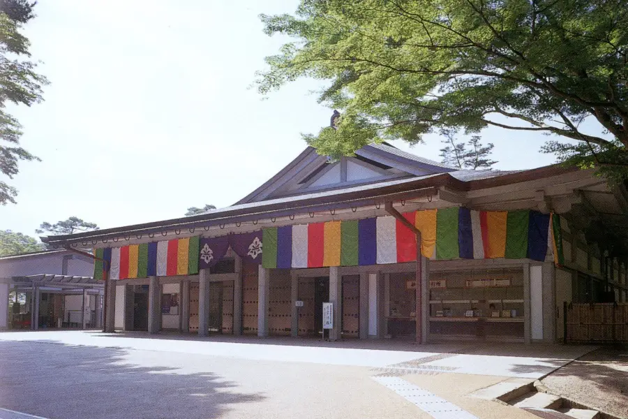 木立の中に建つ、五色の幕が掲げられた中尊寺の宝物館「讃衡蔵（さんこうぞう）」の外観